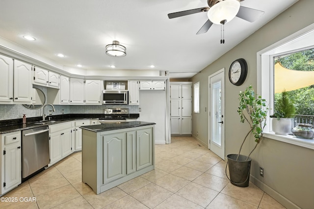 3310 Tana St, Joplin, MO 64804 - kitchen featuring stainless steel appliances, tasteful backsplash, light tile patterned floors, a center island, and a ceiling fan