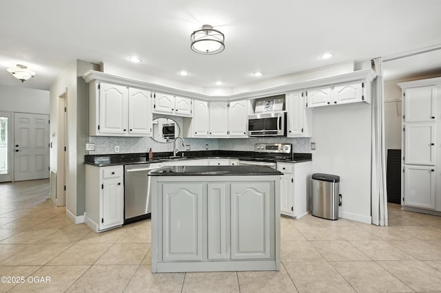 3310 Tana St, Joplin, MO 64804 - kitchen featuring appliances with stainless steel finishes, dark countertops, light tile patterned floors, decorative backsplash, and white cabinetry