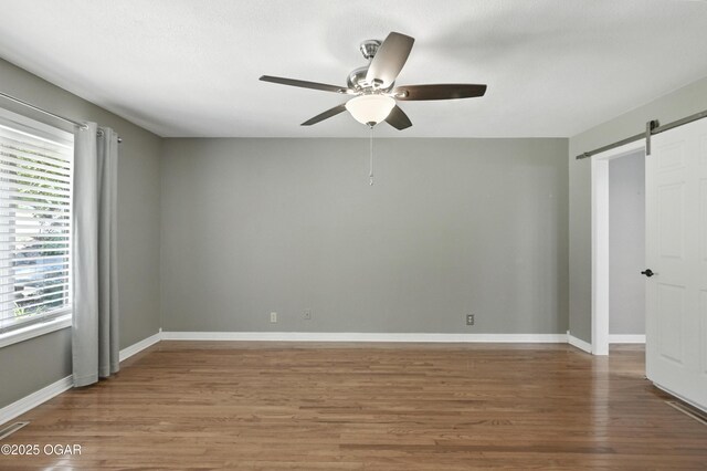 3310 Tana St, Joplin, MO 64804 - unfurnished room with a ceiling fan, a barn door, and wood finished floors