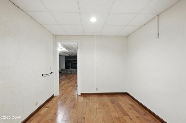 3310 Tana St, Joplin, MO 64804 - spare room with light wood-style floors, a drop ceiling, and a stone fireplace