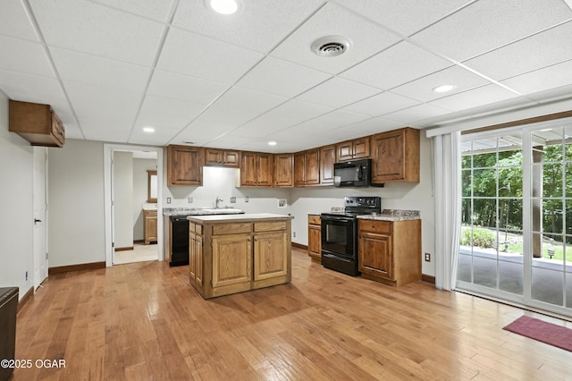 3310 Tana St, Joplin, MO 64804 - kitchen with black appliances, light countertops, light wood finished floors, a drop ceiling, and recessed lighting