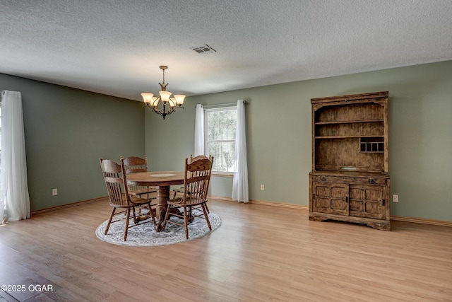 121 Fawn Trl, Seneca, MO 64865 - dining space featuring a chandelier, light wood finished floors, and a textured ceiling