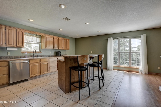 121 Fawn Trl, Seneca, MO 64865 - kitchen with dishwasher, a breakfast bar area, a center island, a textured ceiling, and recessed lighting