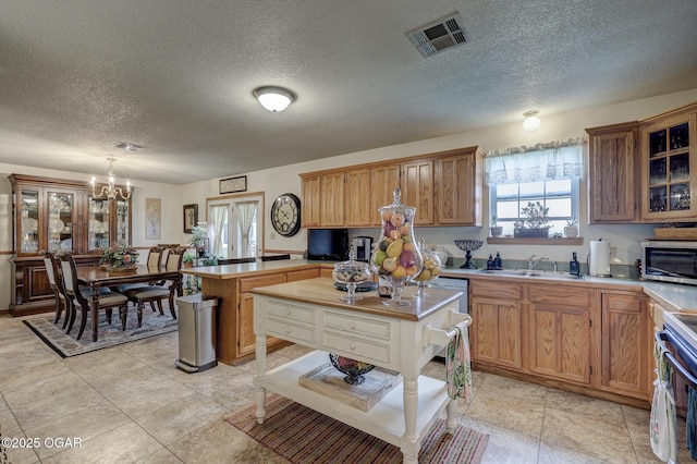 23841 Jaguar Rd, Oronogo, MO 64855 - kitchen with range, a peninsula, a chandelier, plenty of natural light, and a textured ceiling