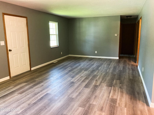 1212 W 12th St, Joplin, MO 64801 - empty room featuring dark wood finished floors and baseboards