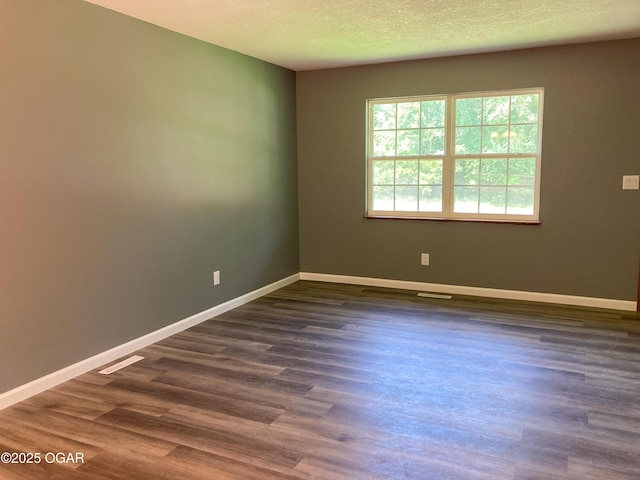 1212 W 12th St, Joplin, MO 64801 - spare room featuring dark wood-style floors and a textured ceiling