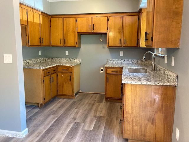 1212 W 12th St, Joplin, MO 64801 - kitchen featuring brown cabinets, wood finished floors, and light stone countertops