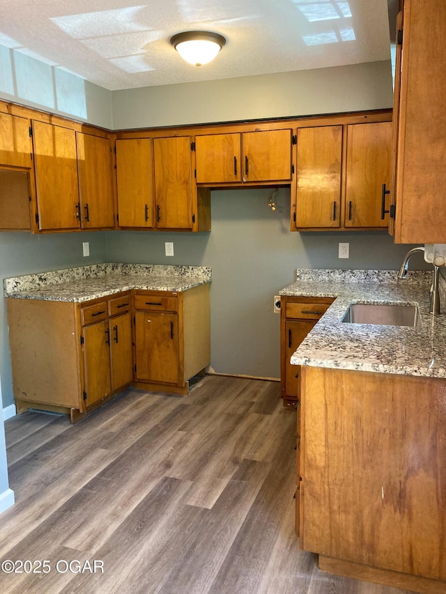 1212 W 12th St, Joplin, MO 64801 - kitchen with brown cabinetry, wood finished floors, and light stone countertops