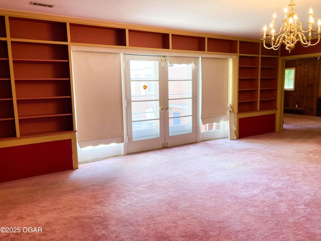 25399 Demott Dr, Joplin, MO 64801 - unfurnished living room with a chandelier, carpet flooring, french doors, and built in shelves
