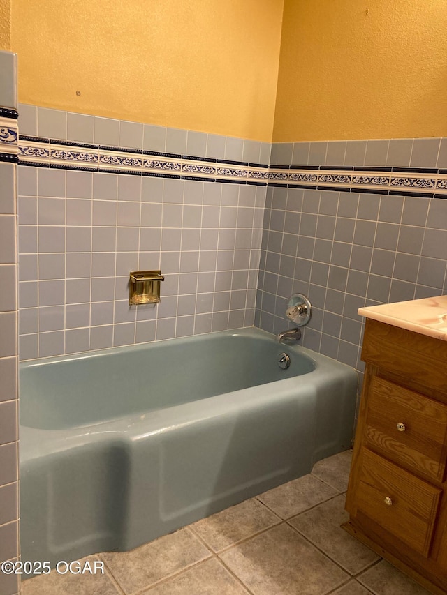 25399 Demott Dr, Joplin, MO 64801 - full bath featuring a bathtub, vanity, tile patterned flooring, tile walls, and a textured wall