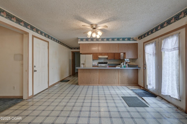 302 E Market St, Diamond, MO 64840 - kitchen with white appliances, under cabinet range hood, a peninsula, light floors, and ceiling fan