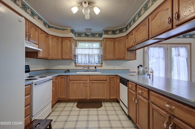 302 E Market St, Diamond, MO 64840 - kitchen featuring white appliances, under cabinet range hood, light floors, a textured ceiling, and brown cabinetry