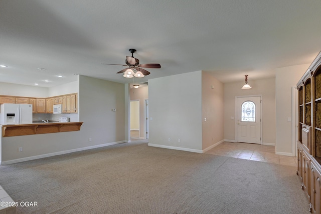 3024 N Chandler Ave, Joplin, MO 64801 - unfurnished living room with light colored carpet, a ceiling fan, and light tile patterned floors