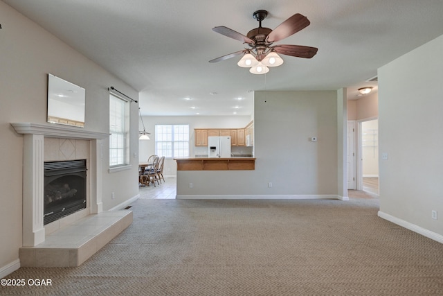 3024 N Chandler Ave, Joplin, MO 64801 - unfurnished living room with light colored carpet, a ceiling fan, a tiled fireplace, and recessed lighting