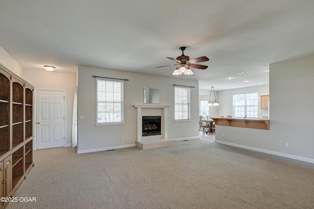 3024 N Chandler Ave, Joplin, MO 64801 - unfurnished living room with a ceiling fan, light colored carpet, and a tiled fireplace