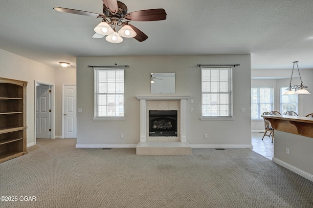 3024 N Chandler Ave, Joplin, MO 64801 - unfurnished living room with a ceiling fan, light carpet, and a fireplace