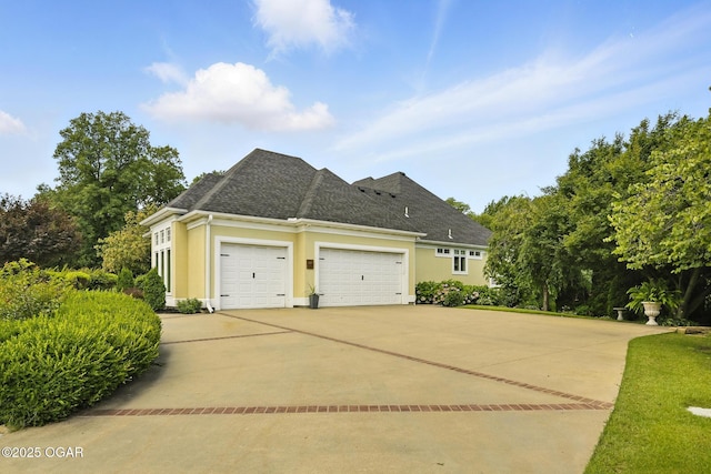 5738 Deer Park Ln, Joplin, MO 64804 - view of side of property with an attached garage, stucco siding, driveway, and roof with shingles