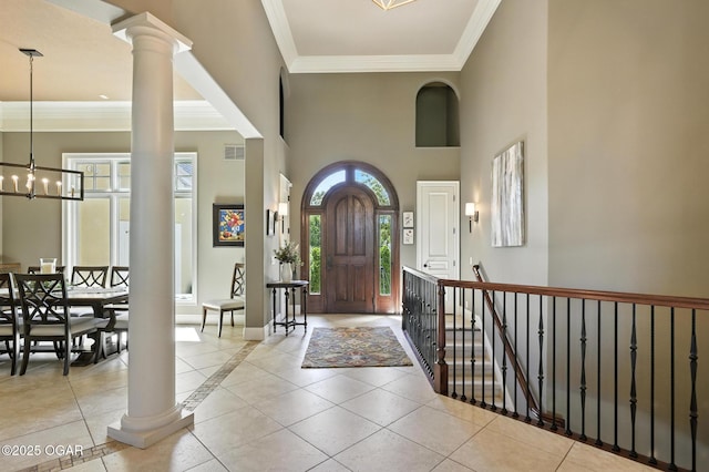 5738 Deer Park Ln, Joplin, MO 64804 - foyer featuring ornate columns, ornamental molding, a towering ceiling, a chandelier, and tile patterned flooring