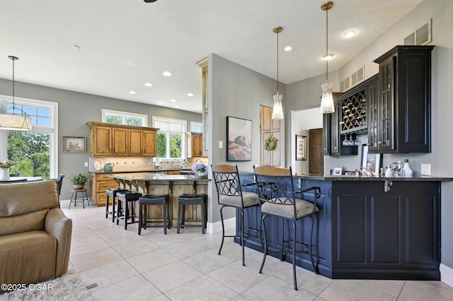 5738 Deer Park Ln, Joplin, MO 64804 - kitchen featuring a peninsula, a breakfast bar area, light tile patterned floors, tasteful backsplash, and recessed lighting