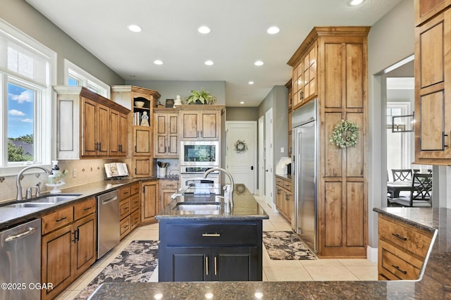 5738 Deer Park Ln, Joplin, MO 64804 - kitchen featuring built in appliances, plenty of natural light, decorative backsplash, recessed lighting, and a center island with sink