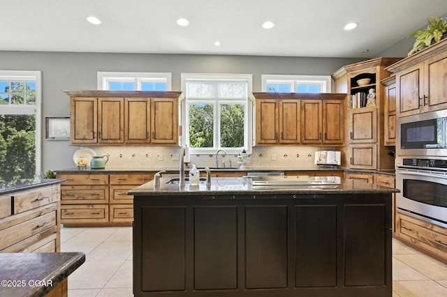 5738 Deer Park Ln, Joplin, MO 64804 - kitchen featuring stainless steel appliances, a kitchen island with sink, recessed lighting, brown cabinets, and plenty of natural light