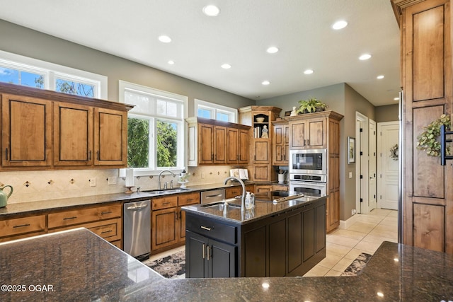 5738 Deer Park Ln, Joplin, MO 64804 - kitchen featuring stainless steel appliances, brown cabinets, recessed lighting, backsplash, and dark stone counters