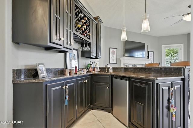 5738 Deer Park Ln, Joplin, MO 64804 - kitchen featuring refrigerator, a peninsula, light tile patterned floors, dark stone countertops, and decorative light fixtures