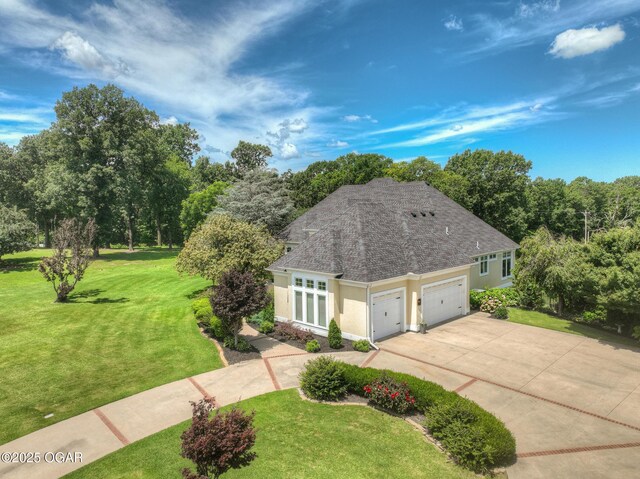 5738 Deer Park Ln, Joplin, MO 64804 - view of front of property with stucco siding, a garage, a shingled roof, and driveway