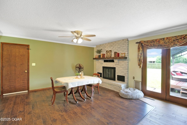 3508 Dirr Ave, Parsons, KS 67357 - dining space featuring a fireplace, crown molding, a textured ceiling, wood finished floors, and ceiling fan