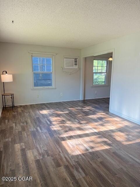 1705 S Walnut St, Pittsburg, KS 66762 - unfurnished living room featuring wood finished floors, an AC wall unit, and a textured ceiling
