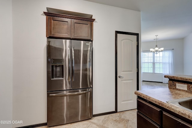 2036 S Ozark, Joplin, MO 64804 - kitchen with stainless steel fridge, dark brown cabinetry, and a chandelier