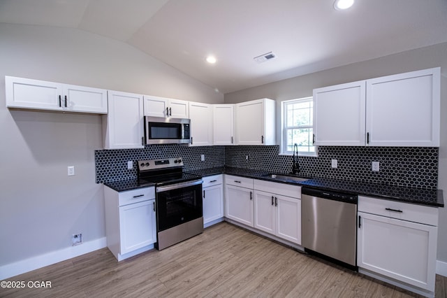 512 N Devon Ave, Webb City, MO 64870 - kitchen with stainless steel appliances, lofted ceiling, white cabinets, dark countertops, and backsplash
