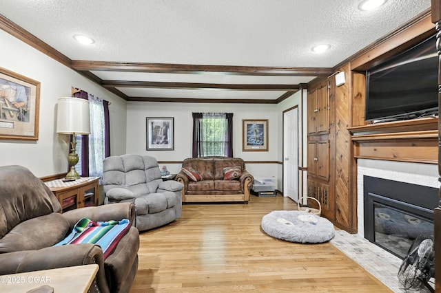 25327 Central Ave, Joplin, MO 64801 - living room featuring a textured ceiling, light wood-type flooring, crown molding, a tiled fireplace, and beamed ceiling