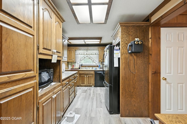 25327 Central Ave, Joplin, MO 64801 - kitchen with black appliances, light wood finished floors, and brown cabinets