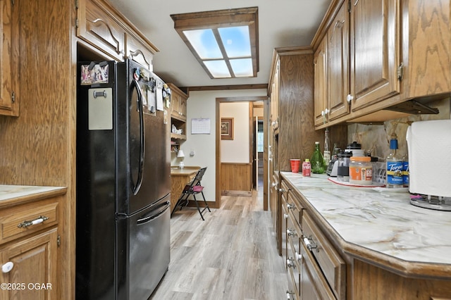 25327 Central Ave, Joplin, MO 64801 - kitchen with freestanding refrigerator, light countertops, brown cabinets, and light wood-style floors