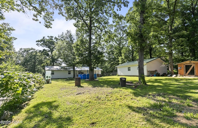 137 Lone Elm Dr, Carl Junction, MO 64834 - view of green lawn featuring a storage shed and view of wooded area