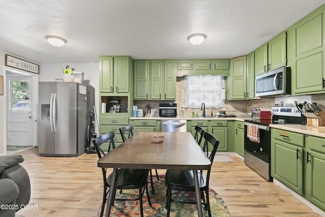 137 Lone Elm Dr, Carl Junction, MO 64834 - kitchen with stainless steel appliances, light wood-style floors, a textured ceiling, light countertops, and backsplash
