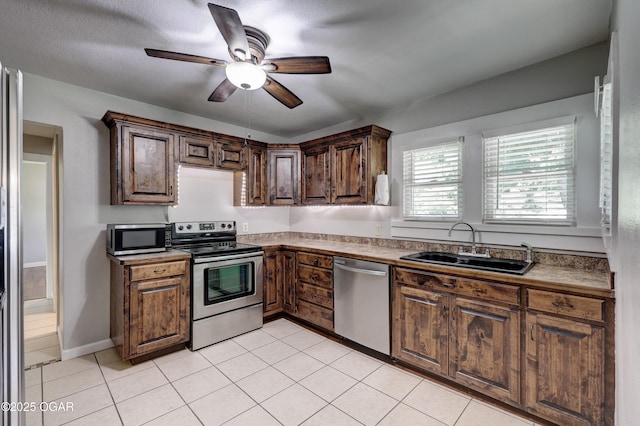 605 S Jefferson St, Webb City, MO 64870 - kitchen with appliances with stainless steel finishes, a ceiling fan, and light tile patterned floors