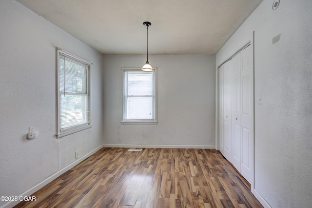 605 S Jefferson St, Webb City, MO 64870 - unfurnished dining area with wood finished floors and a textured wall