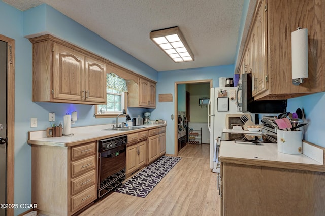 1501 Ryan Rd, Joplin, MO 64801 - kitchen with black dishwasher, light countertops, light wood-type flooring, a textured ceiling, and washer / dryer