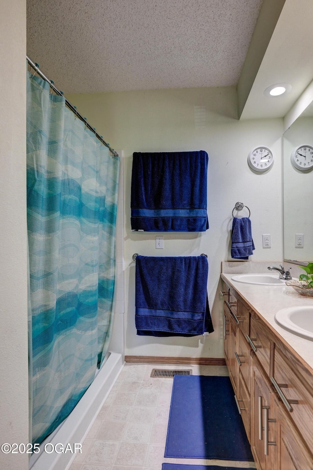 1501 Ryan Rd, Joplin, MO 64801 - bathroom with double vanity, a textured ceiling, a shower with curtain, and recessed lighting