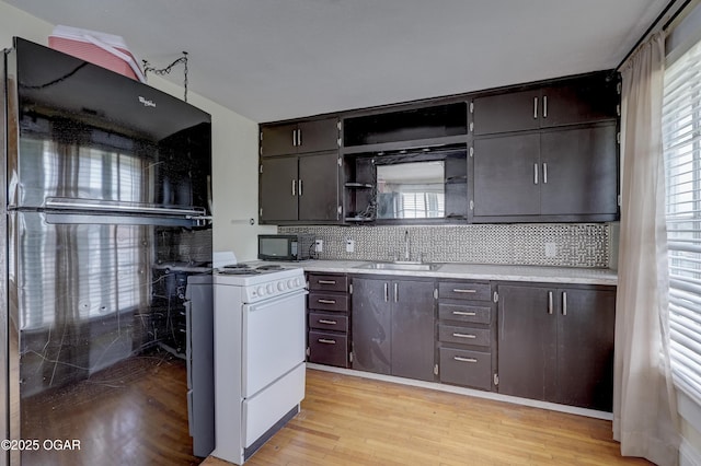 119 S Moffet Ave, Joplin, MO 64801 - kitchen with black appliances, light wood finished floors, light countertops, open shelves, and backsplash