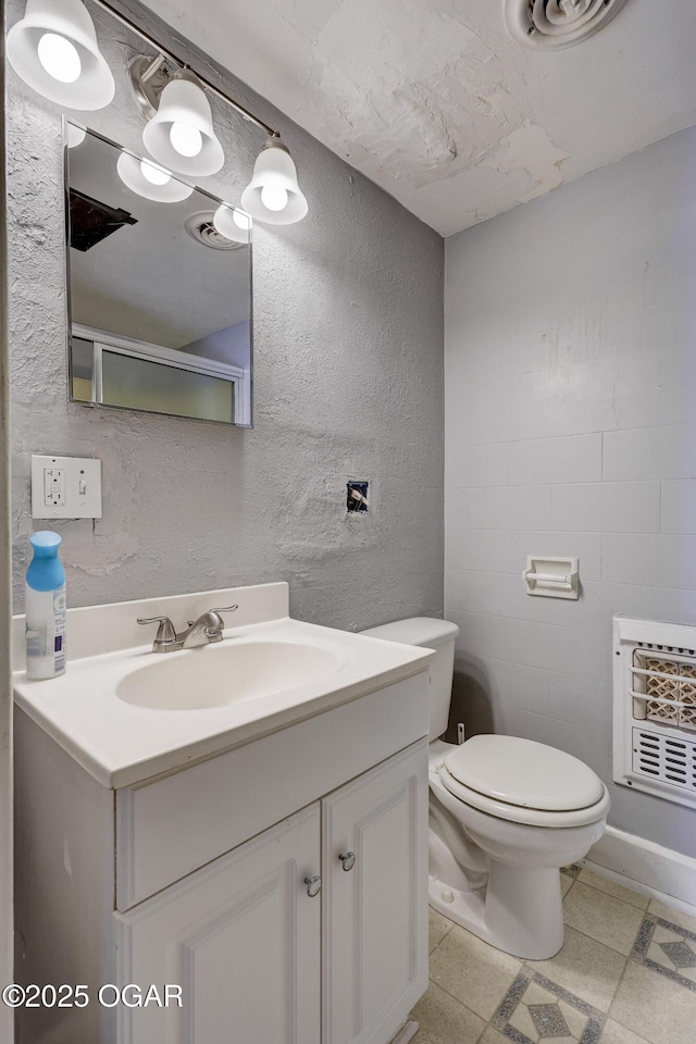 119 S Moffet Ave, Joplin, MO 64801 - bathroom featuring vanity, heating unit, a textured wall, and tile patterned floors