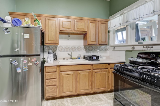 119 S Moffet Ave, Joplin, MO 64801 - kitchen featuring freestanding refrigerator, black gas range oven, decorative backsplash, and light countertops