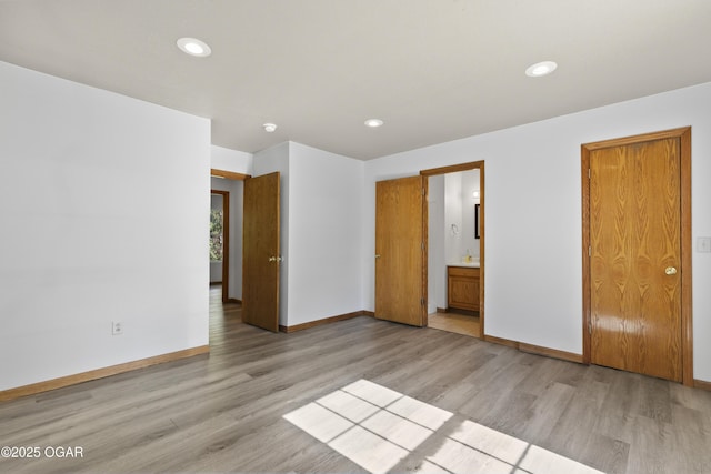 418 W Mccord St, Neosho, MO 64850 - unfurnished bedroom with light wood-type flooring, recessed lighting, and connected bathroom