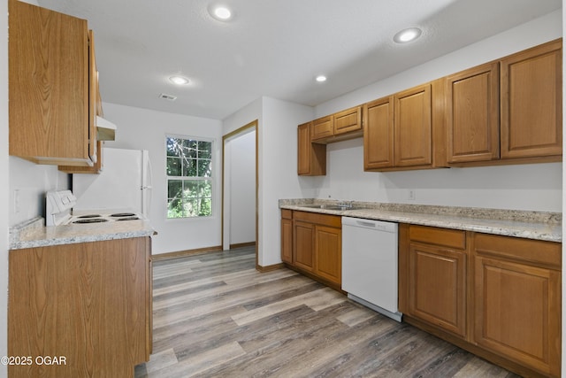 418 W Mccord St, Neosho, MO 64850 - kitchen featuring white appliances, wood finished floors, brown cabinetry, recessed lighting, and under cabinet range hood