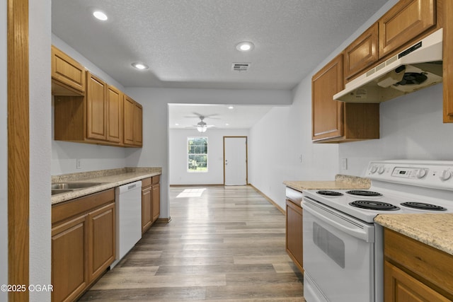 418 W Mccord St, Neosho, MO 64850 - kitchen featuring white appliances, under cabinet range hood, light wood-style floors, recessed lighting, and a textured ceiling