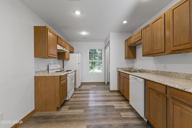 418 W Mccord St, Neosho, MO 64850 - kitchen featuring white appliances, under cabinet range hood, dark wood-style floors, light countertops, and brown cabinets