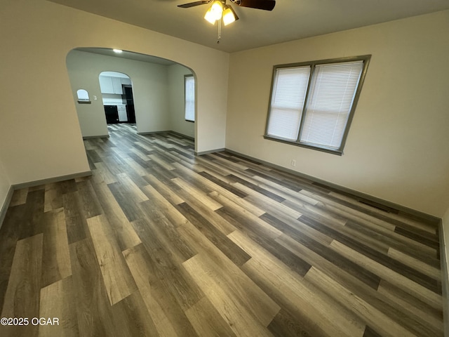 1003 Orchard St, Carthage, MO 64836 - spare room featuring a ceiling fan, arched walkways, and wood finished floors