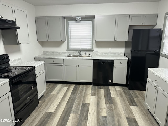1003 Orchard St, Carthage, MO 64836 - kitchen featuring black appliances, under cabinet range hood, light countertops, and healthy amount of natural light